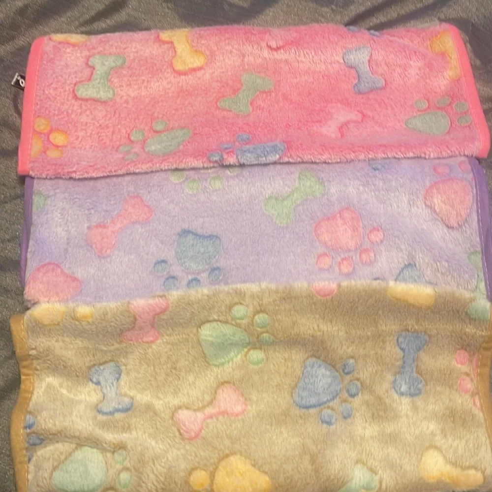 Dog blankets. Never used pack of three. Purple, tan and pink.